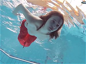 crimson clad teenager swimming with her eyes opened